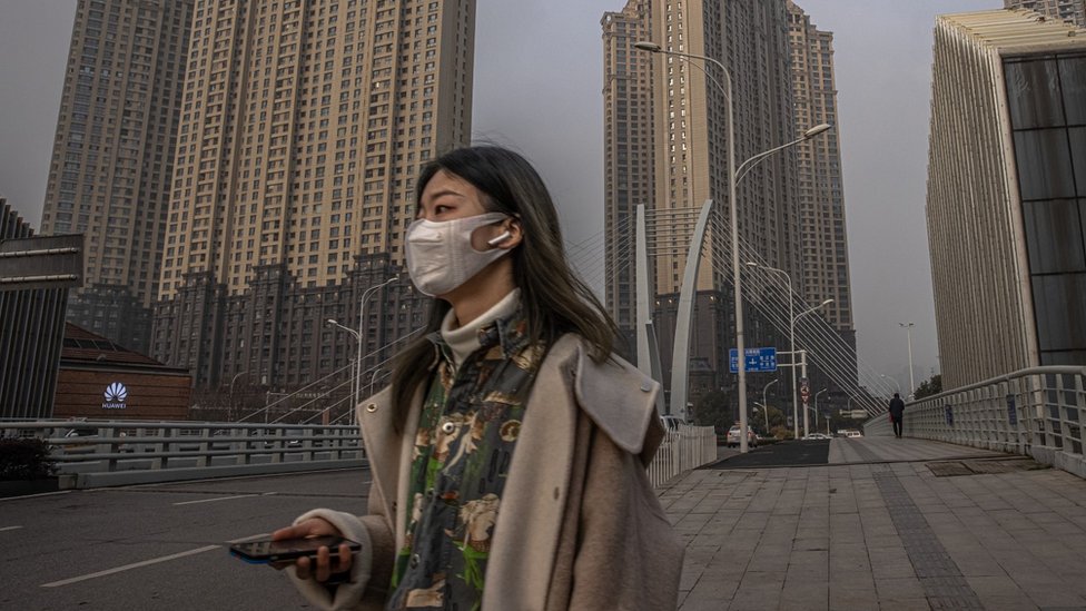 Young woman wearing a face mask, waking in Wuhan, China.