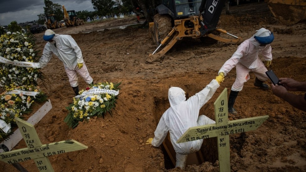 Multiple coffins being buried at a cemetery in Brazil