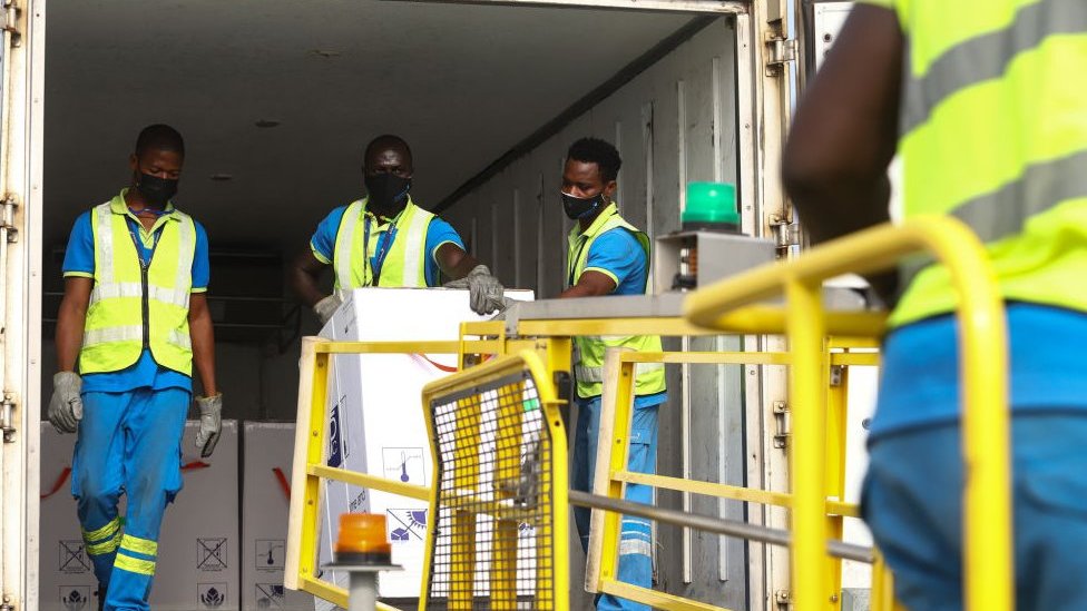 Men in hi-vis jackets dealing with a vaccine delivery